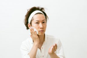 化粧水で肌をケアする男