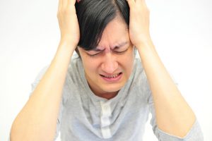 頭を抱えて悩む男