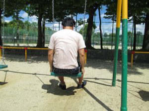 ブランコに座る孤独な男