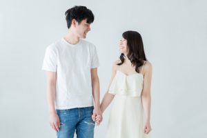 手をつないで見つめ合うカップル